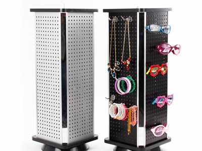 There are two perforated metal spinning display racks. One is white. The other is black where many accessories are hanging.