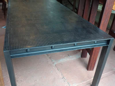 A dinning table with round holes and black surface.