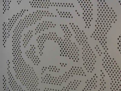 A piece of perforated metal ceiling sheet with round holes and special pattern.